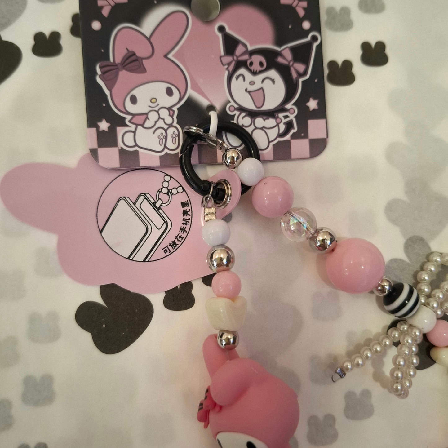 Sanrio – My Melody Telefoonkoord / Phone Strap – Officieel Gelicentieerd – Zachtroze Kawaii Stijl – Met Insteekkaart voor Telefoonhoesje – Luxe Accessoire met Parelstrik, Pluizenbol & Hartjeskralen – Ook als Sleutelhanger of Tassenhanger