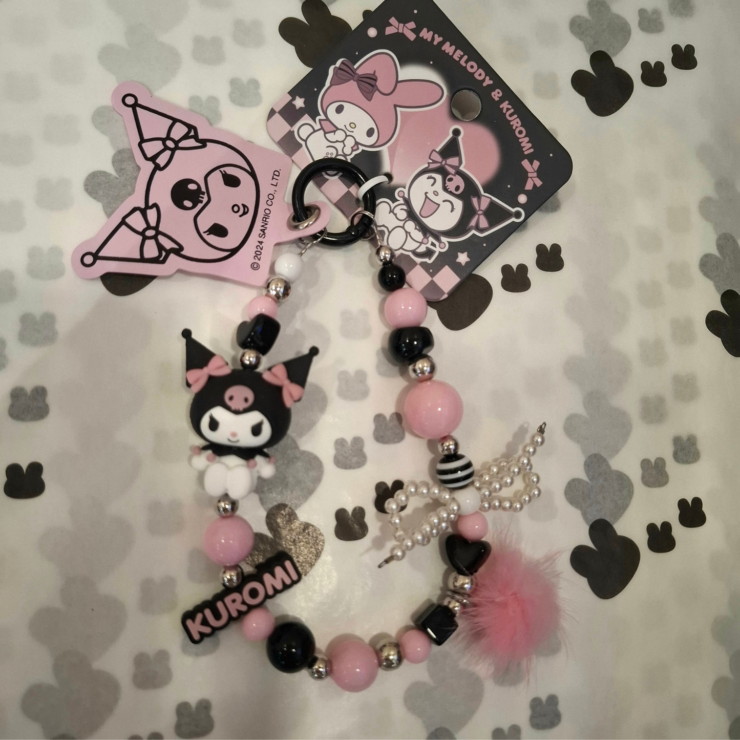 Sanrio – Kuromi Telefoonkoord / Phone Strap – Officieel Gelicentieerd – Zwartroze Serie – Met Insteekkaart voor Je Telefoon – Luxe Kawaii Accessoire met Parelstrik, Pluizenbol & Kralen – Ook als Sleutelhanger of Cadeau